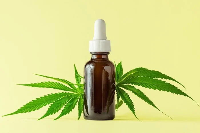 hemp-oil-bottle-on-yellow-background